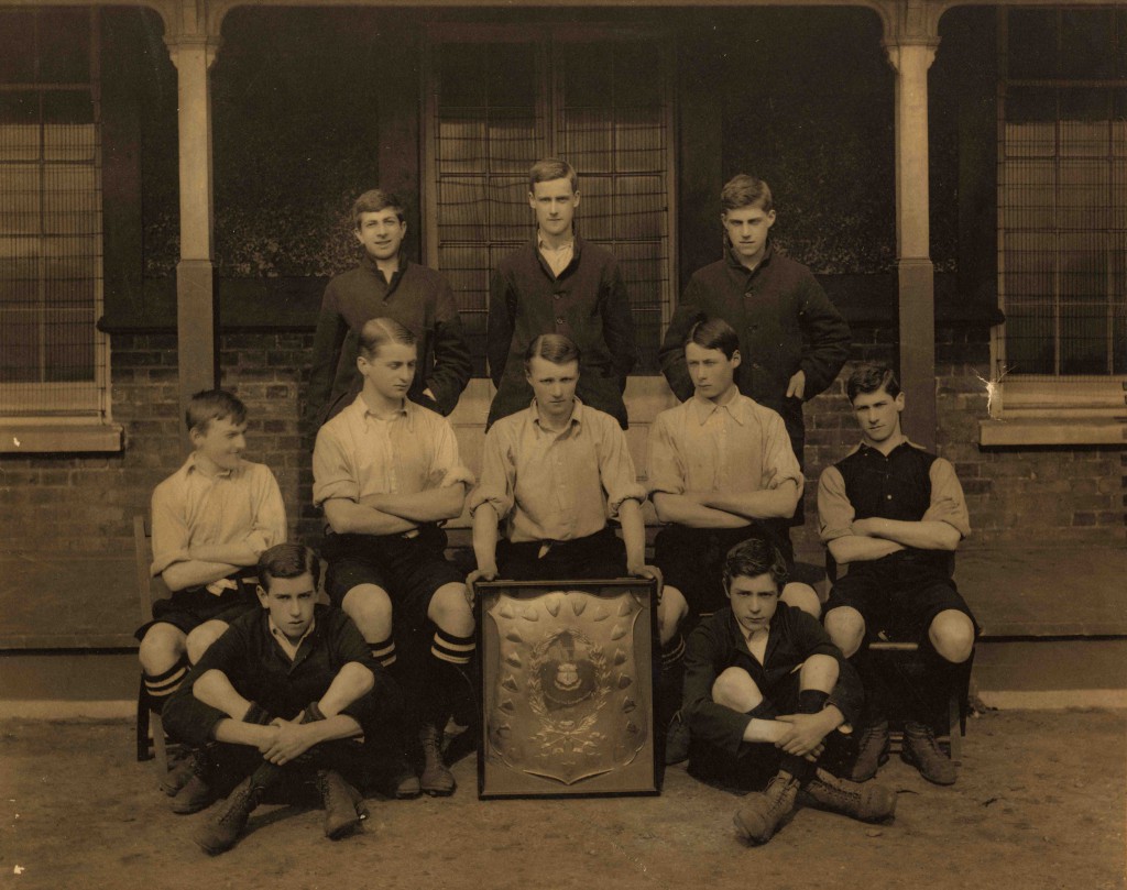 Craig is seated in the centre of the front row, holding on to the trophy.